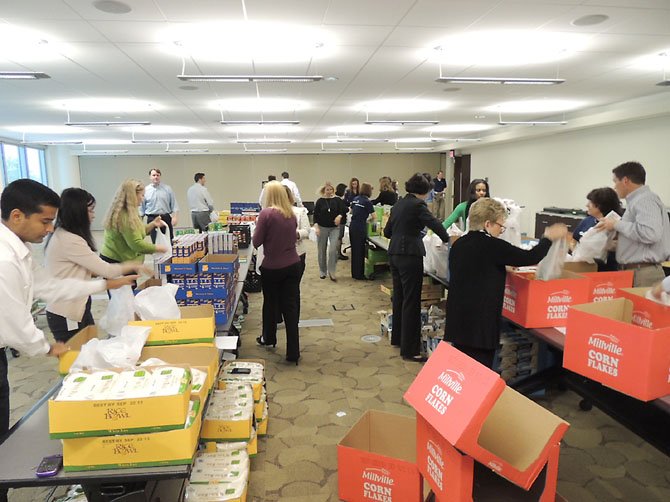 Employees at Capital One assemble food bags to donate to the Lorton Community Action Center (LCAC), a nonprofit organization and food bank based in southeast Fairfax County.

