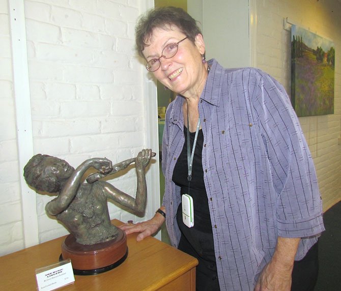 Gwen Harrison Lockhart pictured with one of her works called "The Music Lingers." 