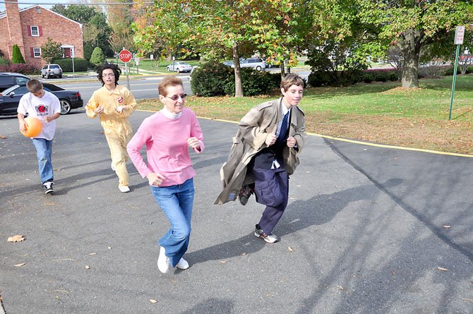 From right, Will Dempsey, 13, Pastor Sandy Kessinger, Michael Petersen, 15, and Christian Markwart, 13, run around the Lutheran Redeemer Church in McLean Saturday, Oct. 27 to raise money for Stop Hunger Now.