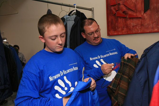 Father and son volunteer and team up to assist needy LINK families by sorting winter coats and sweaters by gender and size at a make-shift clothing store in Sterling United Methodist Church (SUMC). Hundreds of families flow through the LINK clothing store all day and more than 1,000 gently used winter coats, 1,000 mittens and numerous hats, scarves and winter clothing items are distributed to LINK guests. The SUMC Women’s Group and Youth Group support this event. 