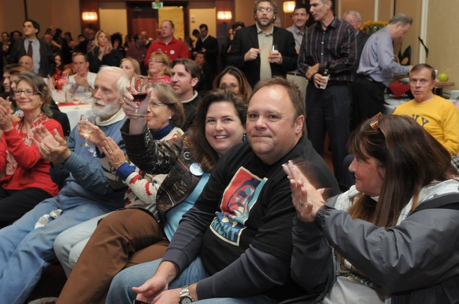 Arlington resident Terill Coggins applauds with Mona Roise and Susan Fletcher who are visiting from Frisco, Texas.