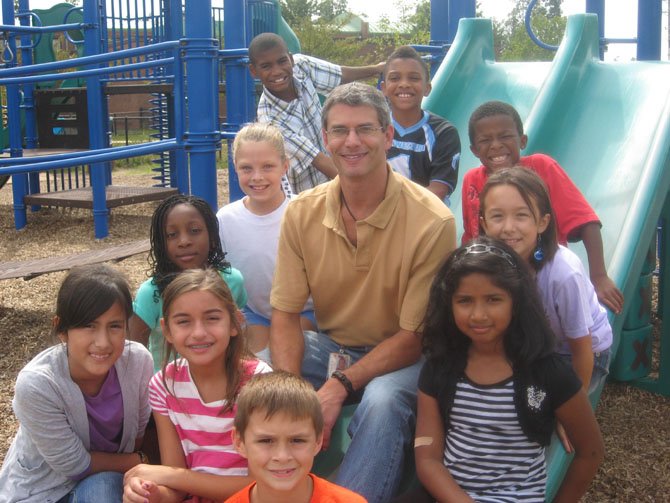 Counselor Lee Kaiser with some Centreville Elementary students on the school playground.

