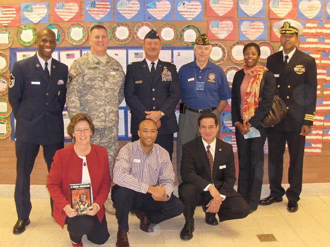 Standing (from left) are Air Force Master Sgt. Kevin Francis, Army CWO Mike Carlson, retired Air Force Maj. Tagg A. Timm, retired Marine Platoon Sgt. and Korean War veteran Frank Spicer, Navy veteran Leontyne Bostick and her husband, Navy Cmdr. Randall Bostick; and kneeling (from left) Colin Powell Elementary Principal Linda Clifford, Air Force veteran Mark Felder and retired Marine Jeffrey Miller.
