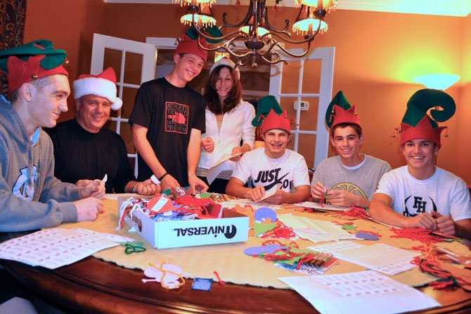 From left: Matt Hagan, Mike Hagan, Drew Magnusson, Kathleen Hagan, Connor Rogers, Kevin Hagan and Reid Lavin attach children’s Christmas-gift wishes to ornaments for ONC 2012 giving trees.
