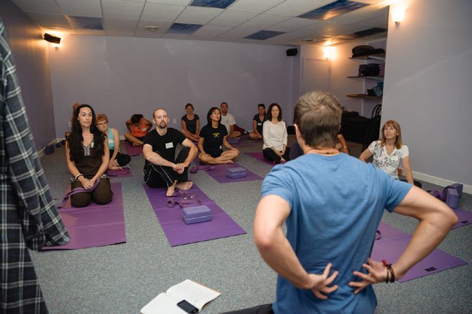 Students prepare to practice yoga at Dream Yoga Studio and Wellness Center in McLean. Experts say confusion and misinformation around yoga can keep some away from the practice.