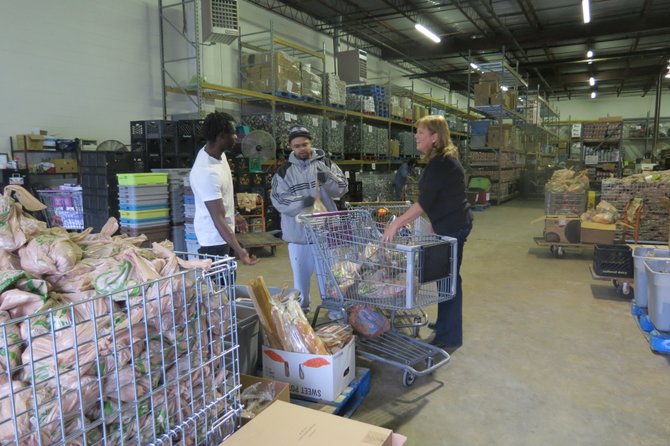 Volunteers help in the Food for Others warehouse on Thursday afternoon.