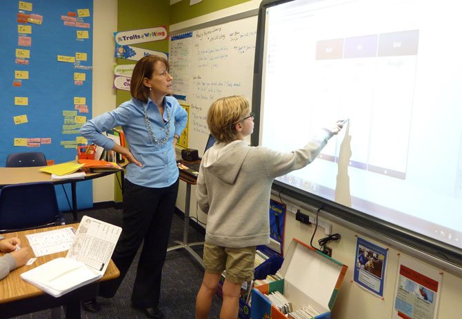 Commonwealth Academy reading and writing specialist Jane Furey works with a student in the new Lower School addition following its dedication Nov. 13.