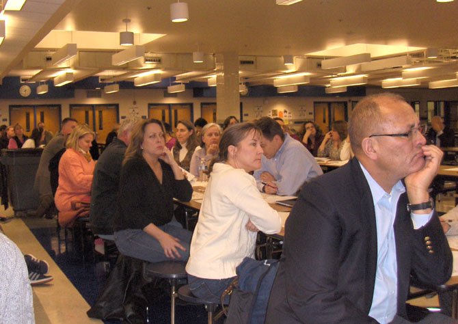 Parents listen to school officials discussing possible boundary changes.