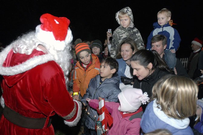 Santa Claus greets children at the Great Falls Tree Lighting ceremony on Sunday evening. The annual event attracts hundreds of area residents and activities including pictures with Santa, Christmas carols, a live Nativity scene and much more.
