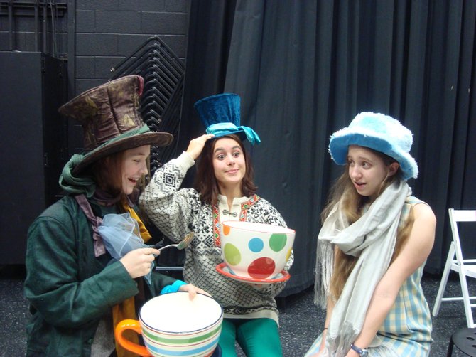 The characters of “Alice in Winter Wonderland,” Cleo Allen-Mills as the Mad Hatter, Isabel Zapata & Lily Lord (Alice) at tea.