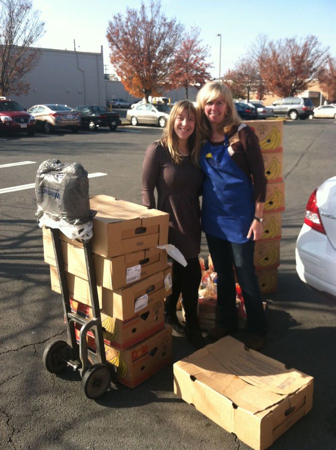 From left are JoAnna Goldberg, director of marketing at Storage Village Self Storage, and Terri Kelly, manager of WFCM’s Food Pantry, accepting the Thanksgiving Food for WFCM clients.