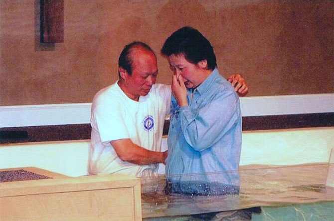 Pastor Isaac Huang of Chantilly Bible Church, who emigrated from Taiwan in 1982, baptizes a fellow Chinese immigrant. 