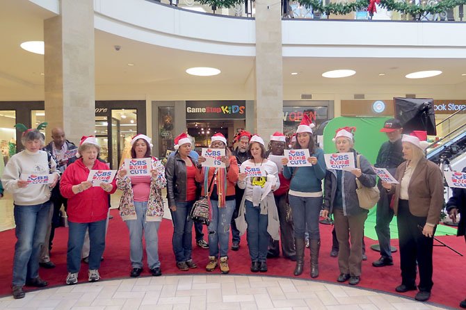 The carolers sang briefly near the Santa set in Tysons Corner Center before being asked by security to discontinue.