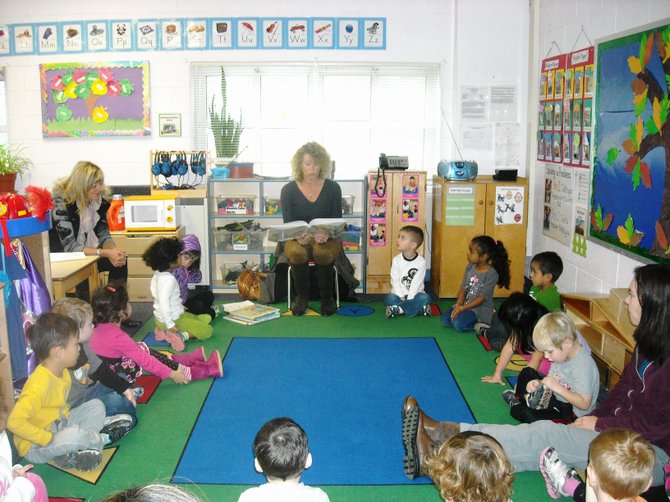 New Dominion Women’s Club of McLean volunteers Susan Adlam (reading) and Bev Brown (left) visited Falls Church-McLean Children’s Center on Nov. 16 to read and distribute books for children to take home and keep. The donations are funded by Macy’s Be Book Smart campaign.