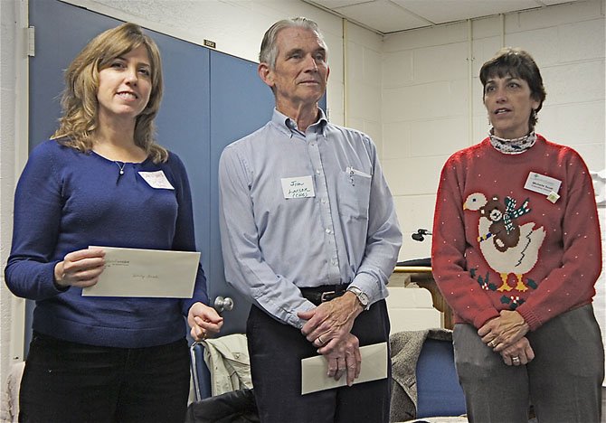 From left--Chris Garris, Food Program manager with Our Daily Bread, Jim Larson, chairman of The Committee for Helping Others, and the Shepherd's Center Executive Director Michelle Scott are all smiles as Scott presents a donation to the two charitable organizations. 
