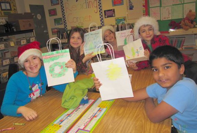 Churchill Road second graders in Cheryl Bamdad’s class are proud of the gift bags they decorated for students at their buddy school, Dogwood Elementary. From left are Emma Cox, Ana Snyder, Lucy Spence, Simonas Pavilionis and Joshua John.