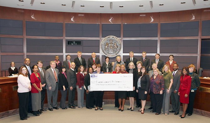 Kelly Brinkley (holding the check on the right), the COO of United Way of the National Capital Area, awards the Community Impact Grant check at the first Fairfax County Board of Supervisors meeting of the year. Surrounding Brinkley are representatives from all the Fairfax/Falls Church grantees.