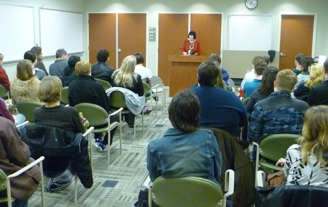 Yorktown High School English and creative writing teacher reads from her first book before a crowd of about 50 people.