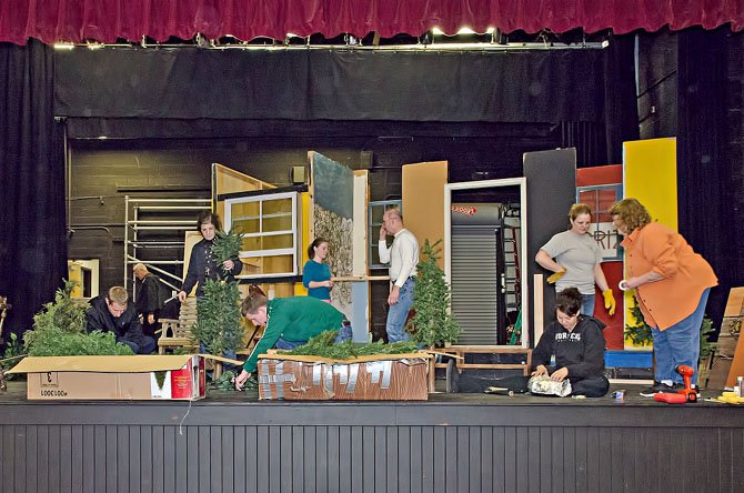 Cast and crew work together to build the set for the Vienna Theatre Company’s winter product of “Proposals,” opening at the Vienna Community Center on January 25.  Director Suzanne Maloney is on right; her father, Norman Chaudet, founded the Vienna Theatre Company in 1974.

