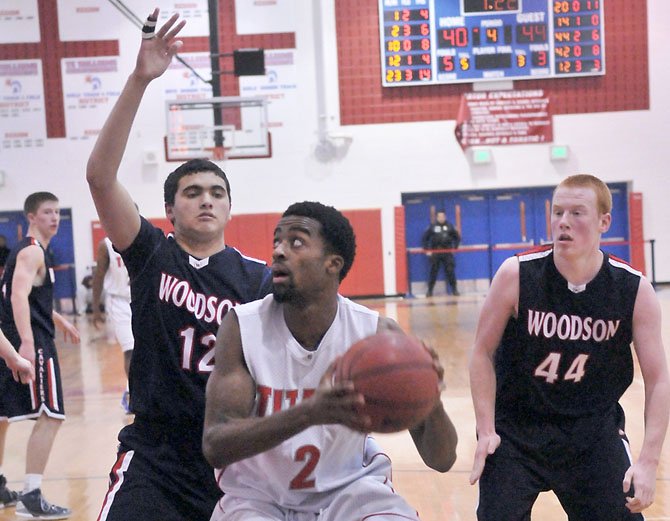 Woodson’s Alex Boock (12) defends T.C. Williams’ Landon Moss as Woodson’s Peter Murray (44) is nearby on Tuesday night at T.C. Williams High School.