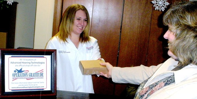 Advanced Hearing Technologies, Inc. associate Sherrie Courson accepting a care package at a local hearing lab.