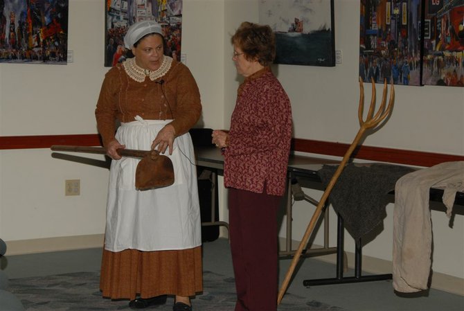 Marion Dobbins shows Mildred Hardman the tool slaves used to work the field. 
