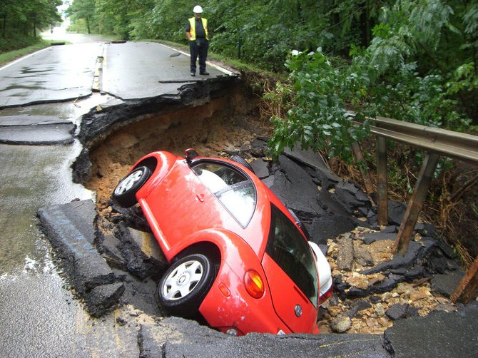 A VDOT crew member assesses damage to Lorton Road after Tropical Storm Lee in Sept. 2011, which destroyed three bridges on secondary roads, damaged pavement on dozens of roads and cost the state $10 million in transportation funds. By law, Virginia must repair damaged roads before spending money to build new ones.