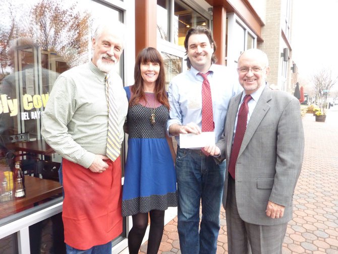 Holy Cow owners “Mango” Mike Anderson, Donna Anderson and Bill Blackburn present ACT Executive Director John Porter with a check for $1,000 Nov. 27 on behalf of the Del Ray gourmet burger restaurant. The restaurant donates 25 cents for every burger sold to an Alexandria charity of the customer's choice.