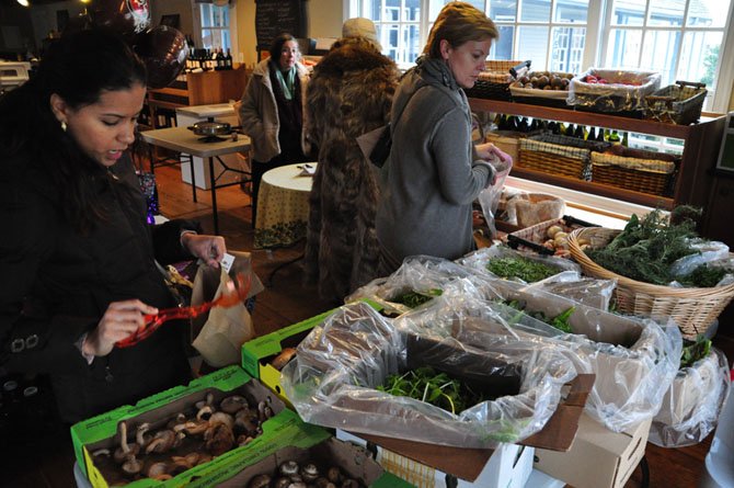 Shoppers browse a selection of greens and other produce at the Great Falls Farmer’s Market Saturday, Feb. 2. The market is happening all winter long, either at its usual site, or inside Maison du Vin on days with below-freezing temperatures.