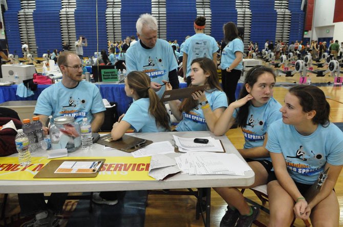 Volunteer Milos Ivanis checks in with the other volunteers on the floor during the erg sprints on Saturday afternoon.