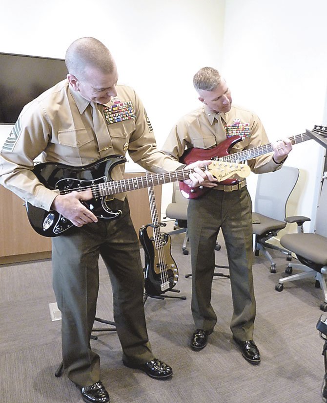 Sgt. Major Bryan Battaglia and Brigadier General Eric Smith test out guitars in the music room of the new USO facility at Fort Belvoir.