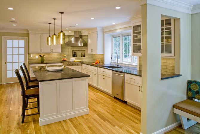 Brent Wentworth and his team added white-painted cabinetry, glass cabinet doors, dark gray granite countertops, oak floors and pendant light fixtures that he says “will remain functional and stylish for years to come.” 