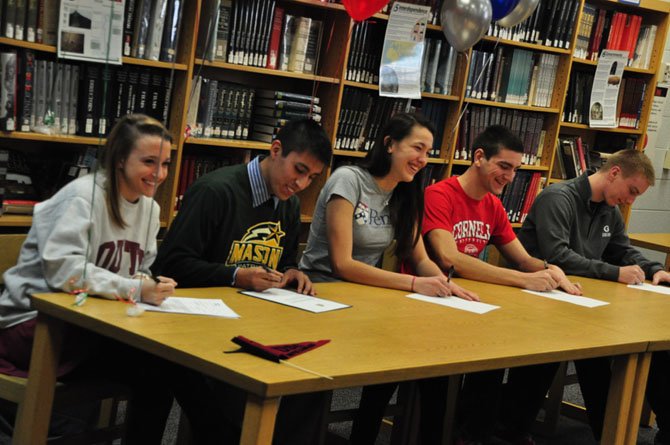 From left, McLean High School seniors Evelyn Robinson (soccer, University of South Carolina), David Galdo (soccer, George Mason University), Lexi Slotkoff (volleyball, University of Pennsylvania), Kris Hobbs (crew, Cornell University) and Robert Longwell (football, Georgetown University) sign their letters of intent to play college athletics next year. 