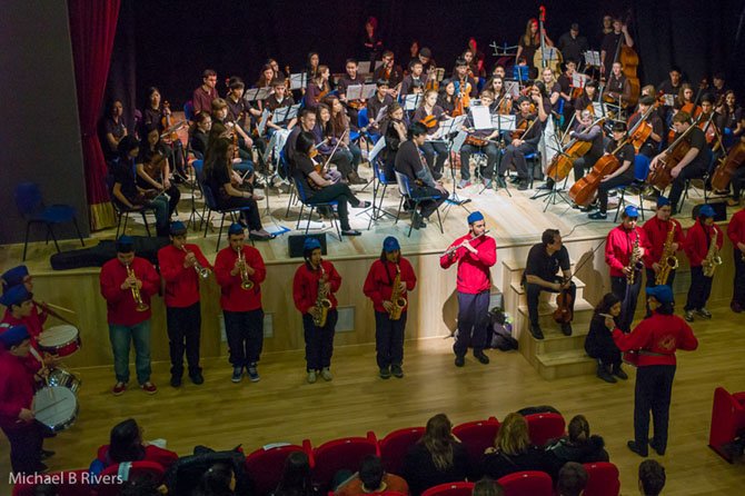 Langley High School Orchestra (onstage) and Italian students (in front of stage) share a concert.