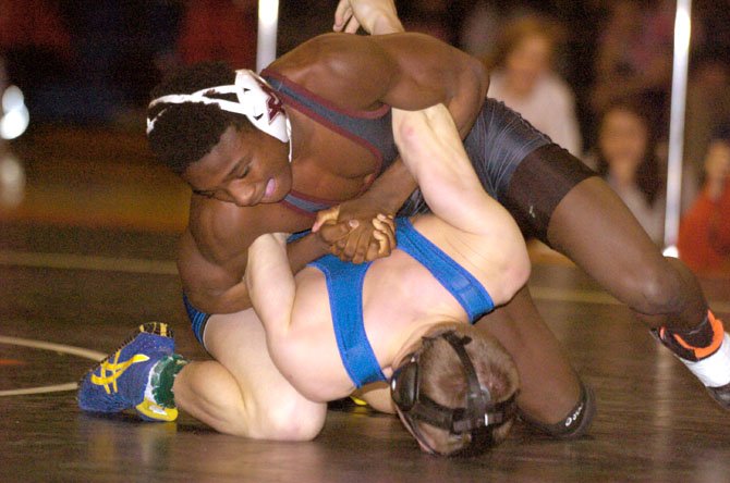 Mount Vernon’s Bill Adusei, top, defeated Robinson’s Austin Riggs via 12-5 decision to win the 126-pound title at the Northern Region wrestling meet on Feb. 9 at Hayfield Secondary School.