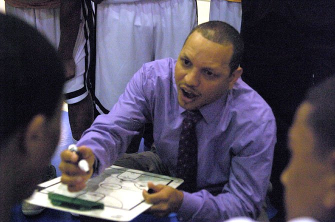 Wakefield head coach Tony Bentley speaks to the Warriors during the Northern Region final against Woodson on Feb. 23 at Robinson Secondary School.
