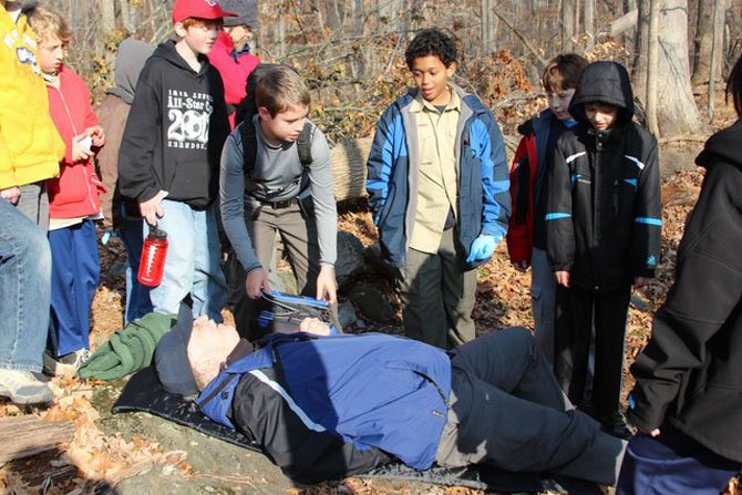 Scouts assist an “injured man” on the path.