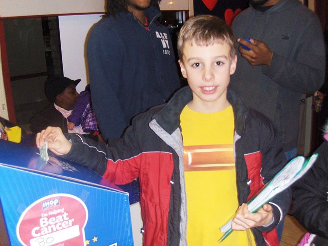 Colin Gegg puts a dollar in the donation box.