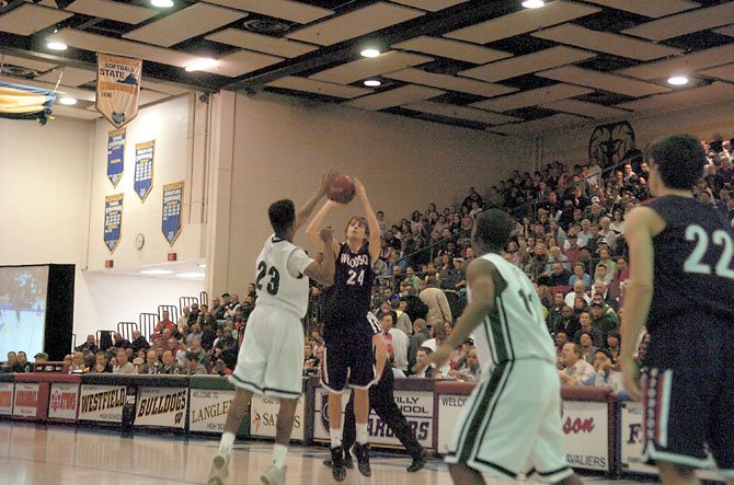 Woodson senior Tommy Stepka shoots while Wakefield’s Ermias Nega defends during the Northern Region tournament final on Feb. 23 at Robinson Secondary School.
