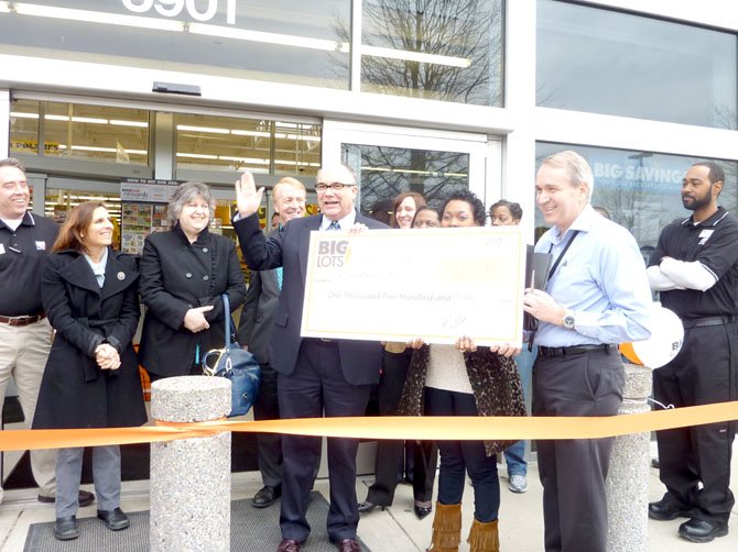 Samuel Tucker Elementary School principal Rene Paschal, center, waves to the crowd after accepting a check for $1,500 from Big Lots district manager Fred Galzerano. The presentation was made March 1 just prior to the formal ribbon-cutting for the new store, located at 5901 Stevenson Ave. across from Landmark Mall.