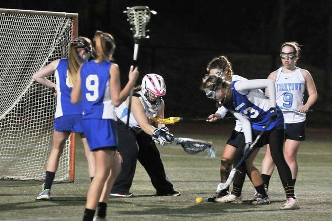 West Potomac senior Karley Zdebski, right, looks to scoop the ball off the turf during Monday night’s game at Yorktown.