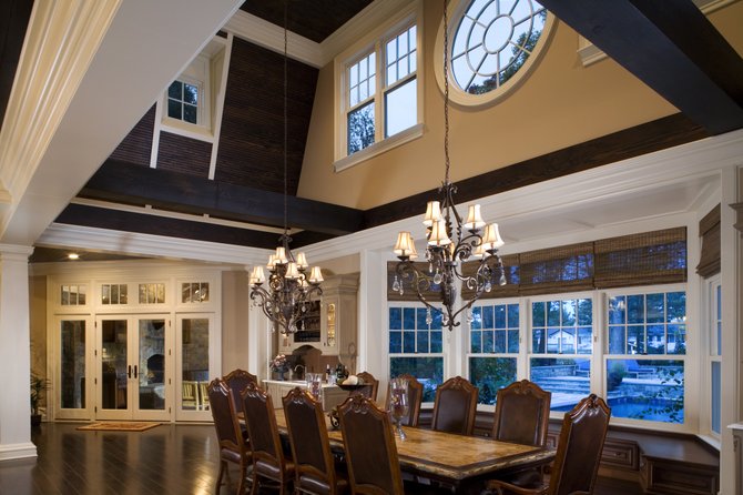 Large windows in the breakfast room of this Potomac home by Rill Architects offer views of the outdoor living room and the pool.
