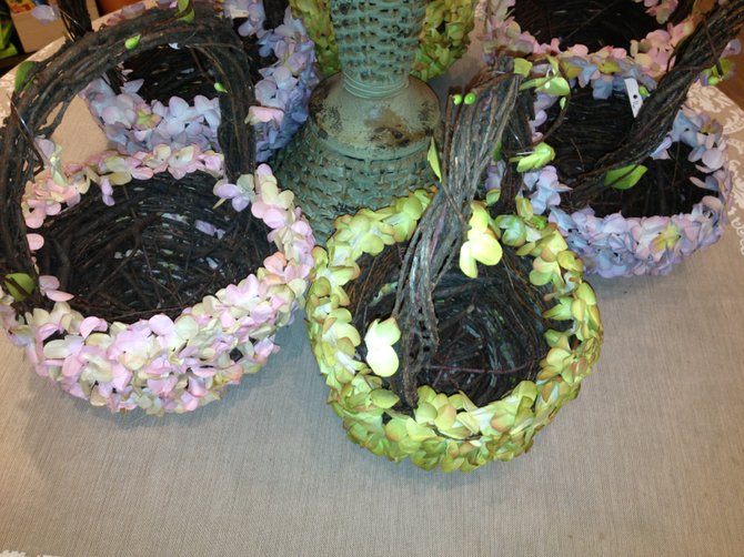 A floral arrangement displayed in baskets covered with spring flower petals makes a chic centerpiece for the dining table.
