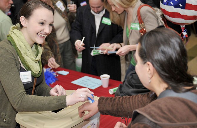 Kaelin Jennison of Fairfax helps people with the straw pole at the 19th Annual St. Patrick’s Day Fete sponsored by Congressman Gerry Connolly on Sunday evening, March 17.