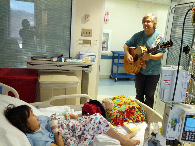 Pickleberry Pie supporter, musician Fred Karam, plays bedside for a sick child at Georgetown University Hospital