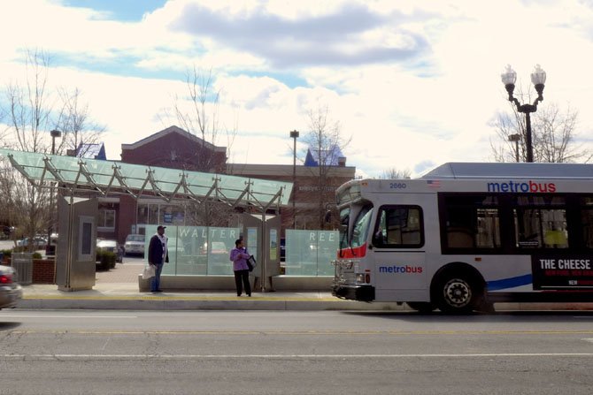 Commuters wait for a bus at the newly opened Walter Reed Super Stop.