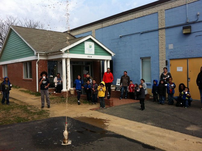 Participants of the Child and Family Network Centers' Super Science Saturday watch as a volcano experiment by pre-schoolers and their families erupts March 14 at the CFNC Birchmere headquarters on Mount Vernon Avenue.