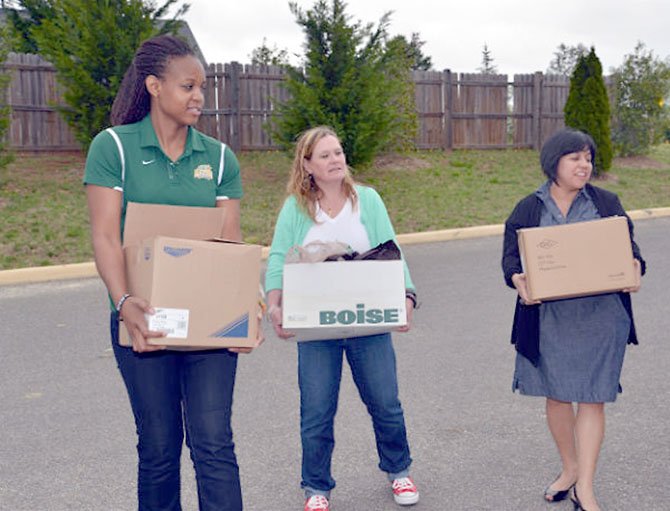 GMU senior Joy Tharrington, Dr. Angie Hattery and Artemis House Director Laly Goodmote carry in the donated items of hygiene products for the shelter residents. 
