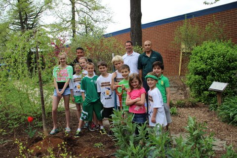 In honor of Earth Day, Churchill Road SCA representatives plant a weeping cherry tree donated by Wheat’s Landscape.  Pictured, from left, are: SCA members Lauren Maloney, Liliana Schone, Izzy Schone, J.J. Bellaschi, Matthew Strong, Whit Walter, Ryan Jones, Jordan Rupli, Joseph Hoeymans and Sam Murad. Wheat’s Certified Arborist Kane Ramsey (center back) and his crew worked with the students to plant the tree.
