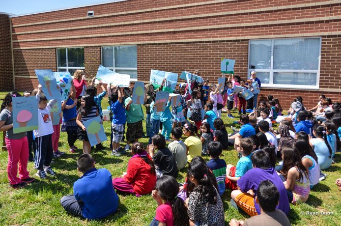 Students at Hutchinson Elementary School display posters they created celebrating Arbor Day.